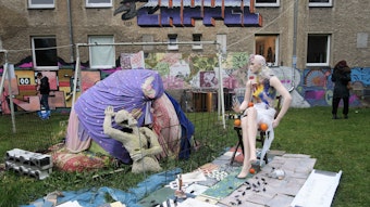 Die Skulptur "Grenzen auf" von Rolf Hartung steht im Innenhof des Wohnquatiers auf einer grünen Wiese.