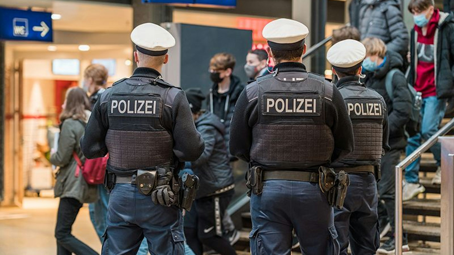 Drei Polizisten stehen vor der Treppe am Hauptbahnhof.