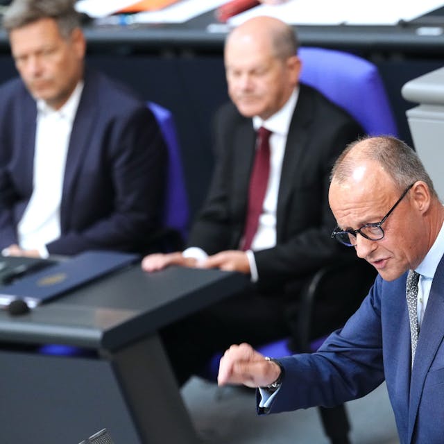 Oppositionsführer Friedrich Merz (CDU, rechts) spricht im Bundestag. im Hintergrund Kanzler Olaf Scholz (SPD, Mitte) und Vizekanzler Robert Habeck (Grüne).
