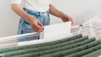 Eine Frau hängt Wäsche auf einen Wäscheständer.