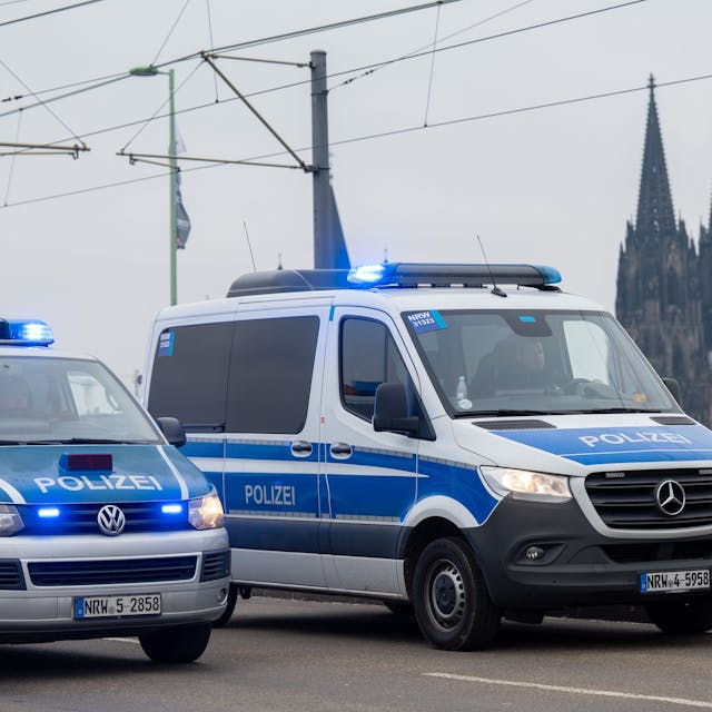 Zu sehen sind zwei Mannschaftswagen der Polizei Köln auf der Deutzer Brücke. Im Hintergrund zu sehen ist der Kölner Dom.