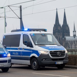 Zu sehen sind zwei Fahrzeuge der Polizei auf der Deutzer Brücke in Köln. Im Hintergrund ist der Kölner Dom zu sehen.