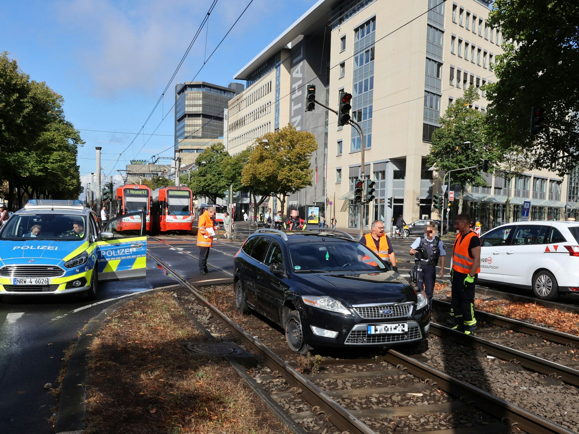Schwarzer Ford steht in Köln im Gleisbett. Daneben stehen Autos der Polizei, im Hintergrund müssen Bahnen der KVB warten.
