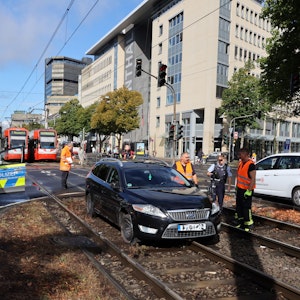 Schwarzer Ford steht in Köln im Gleisbett. Daneben stehen Autos der Polizei, im Hintergrund müssen Bahnen der KVB warten.