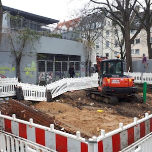 Die Baustelle auf dem Wilhelmsplatz mit abgesperrter Zone und Bagger.