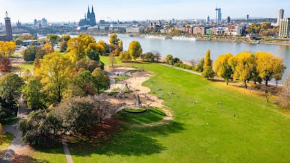 Blick auf einen herbstlichen Park am Rhein in Köln