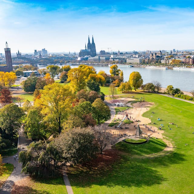 Blick auf einen herbstlichen Park am Rhein in Köln
