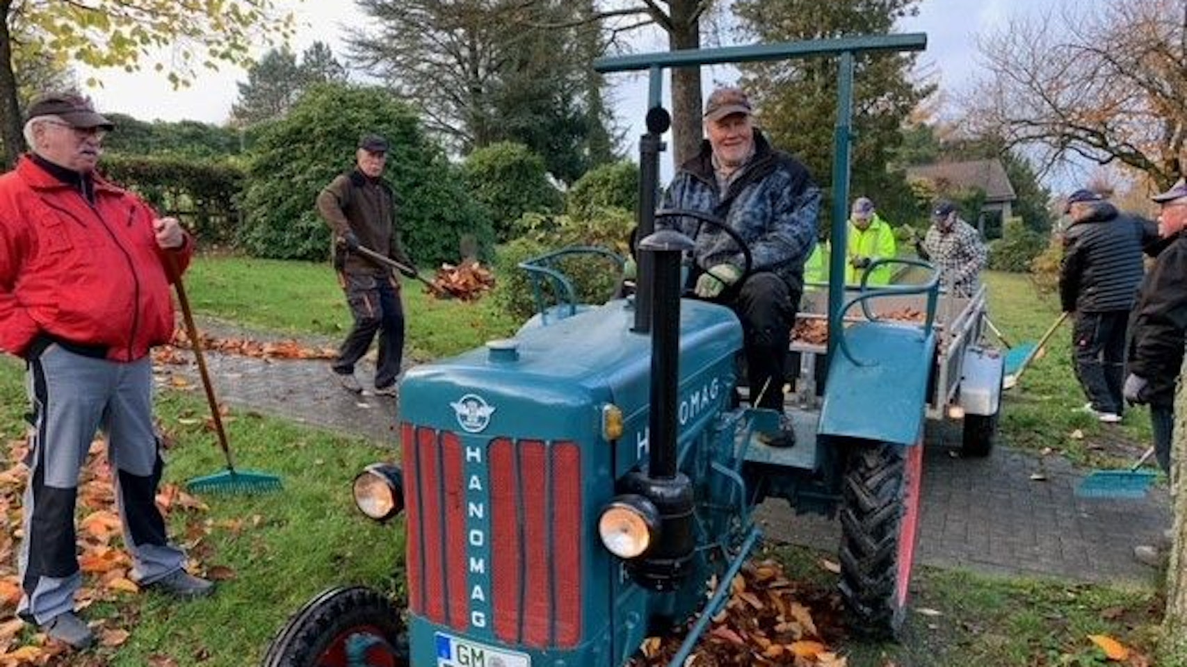 Die ehrenamtlichen Friedhofsgärtner arbeiten in Müllenbach mit einem kleinen blauen Traktor.