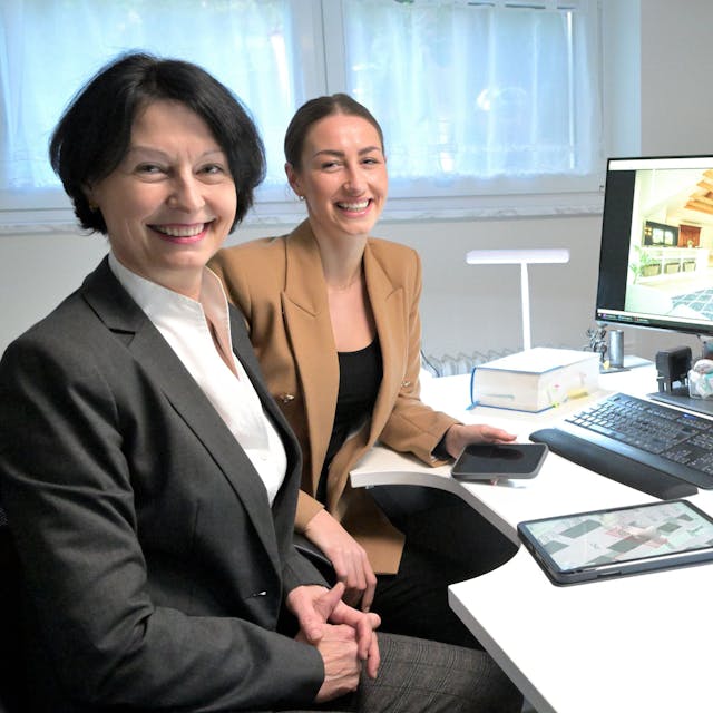 Gabriele Kreileder-Heitz und Blanca Heitz sitzen vor zwei Computerbildschirmen.