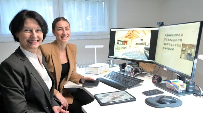 Gabriele Kreileder-Heitz und Blanca Heitz sitzen vor zwei Computerbildschirmen.