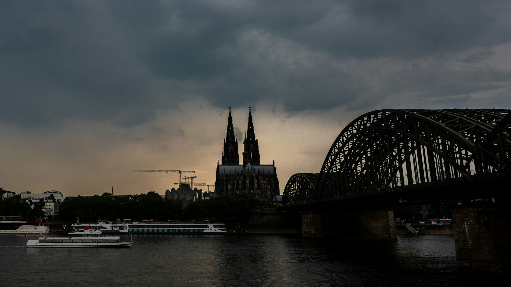 Dunkle Gewitterwolken ziehen über dem Kölner Dom auf. Außerdem ist die Hohenzollernbrücke zu sehen. (Archivbild)