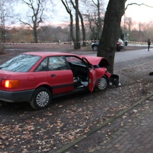 Ein Auto ist völlig ausgebrannt, ein zweites steht mit beschädigter Front an einem Baum.