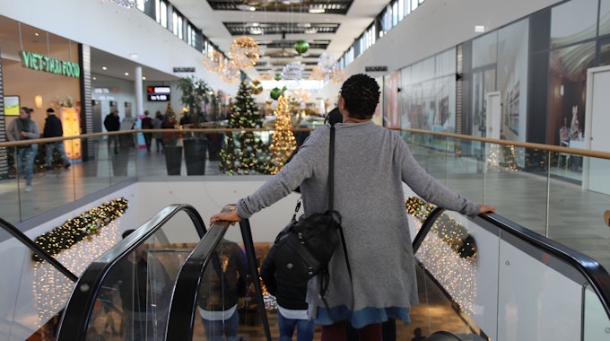 Eine Frau in der Sankt Augustiner Shopping-Welt steht im Dezember 2022 auf einer Rolltreppe.