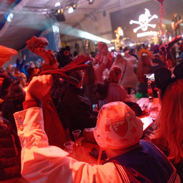 Zuschauer feiern bei einer Karnevalssitzung.