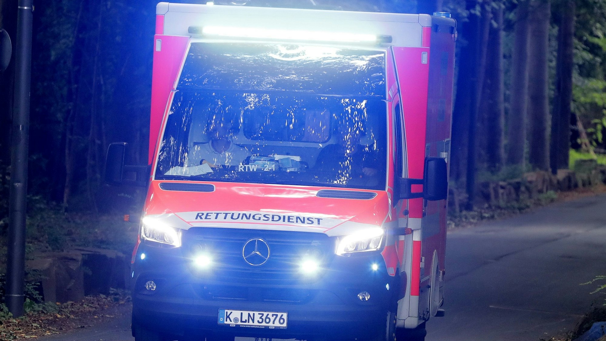 Ein Rettungswagen der Stadt Köln mit Blaulicht auf der Zufahrt zum Geißbockheim.