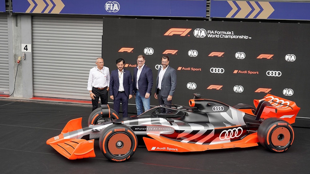 Formel-1-CEO Stefano Domenicali, FIA-Präsident Mohammed bin Sulayem, Audi-Vorstandschef Markus Duesmann und Audi-CTO Oliver Hoffmann stehen hinter einem Model des Formel-1-Autos von Audi.