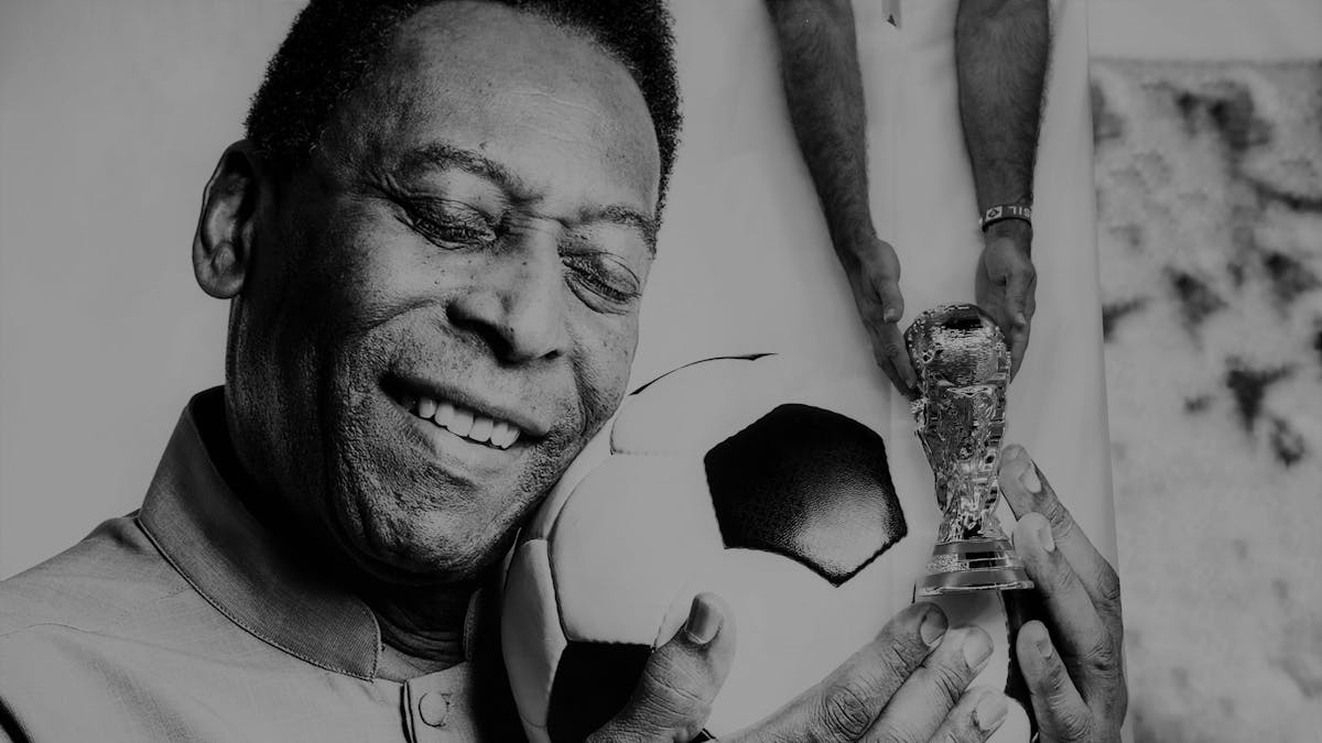 Pelé hält einen Fußball in seinen Händen.&nbsp;