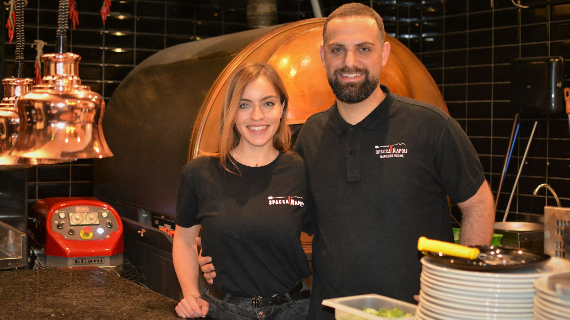 Valentina Guarino und Raffaele Mastellone stehen zusammen vor dem Pizza-Ofen im Spaccanapoli.