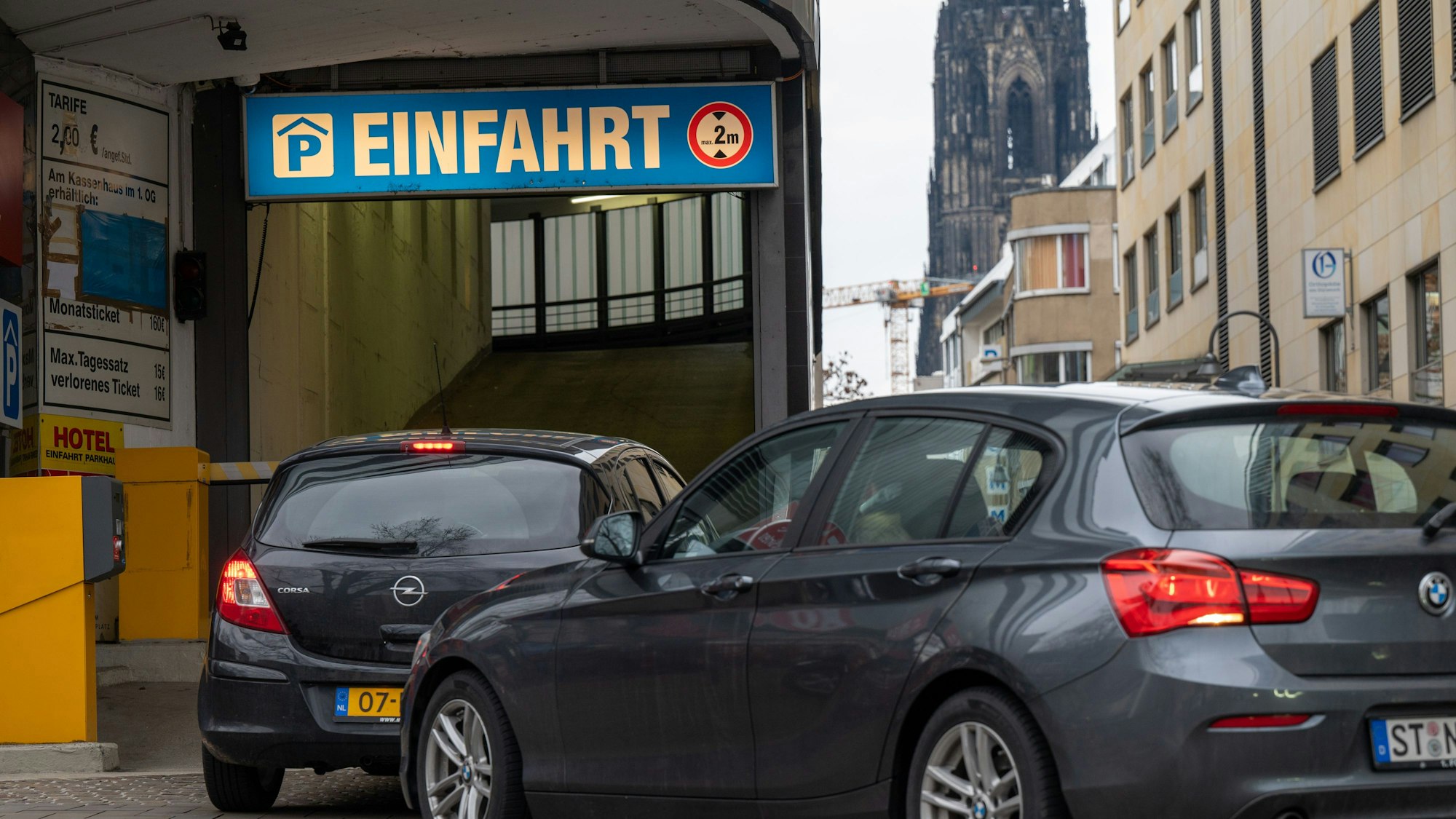 Autos stehen vor der Einfahrt zu einem Parkhaus in der Kölner Innenstadt.