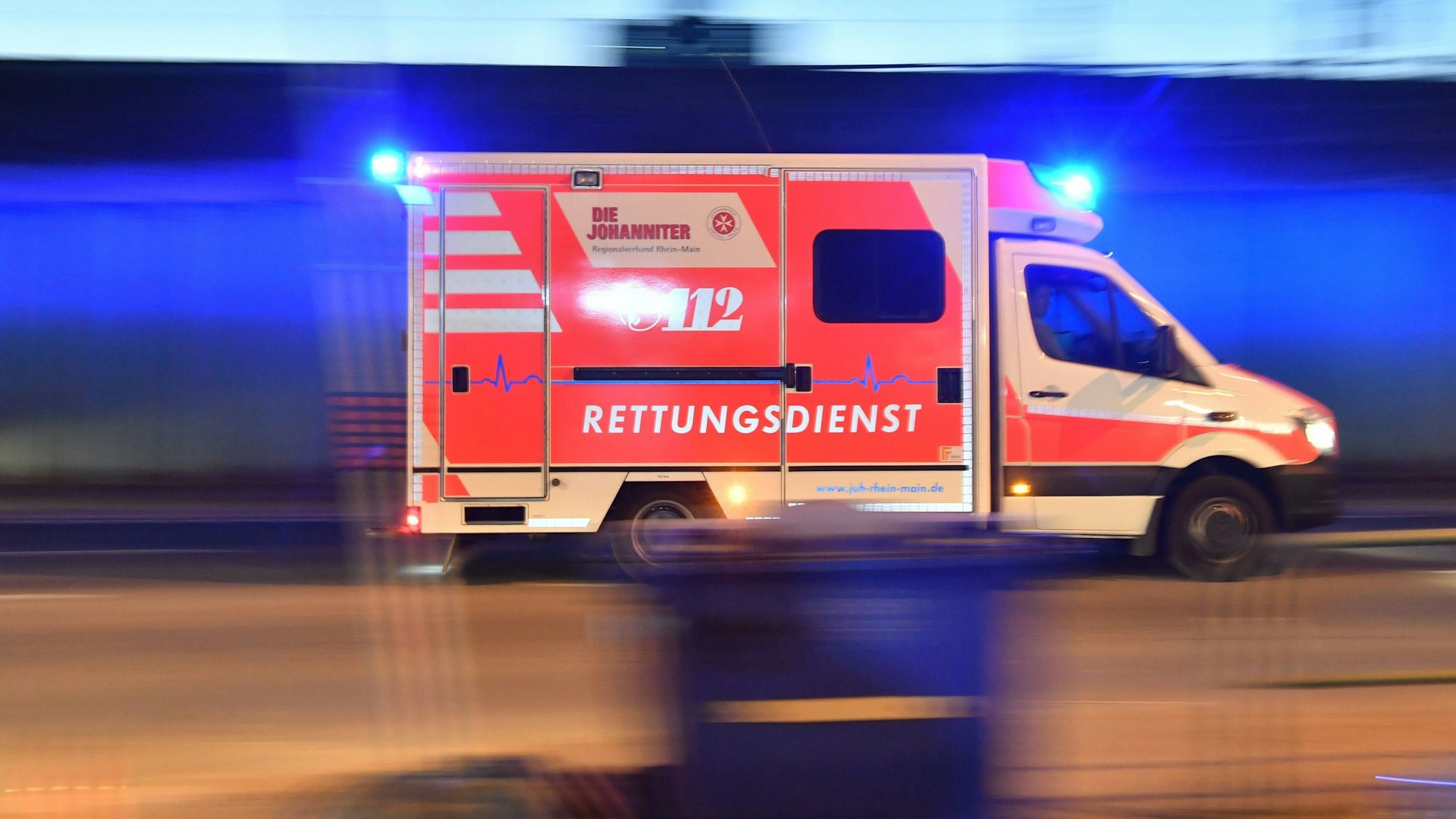 Ein Rettungswagen der Johanniter fährt mit Blaulicht zu einem Einsatzort.