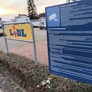 Ein großes, blaues Schild mit sehr langem, kleingedrucken Text steht an der Einfahrt zum Lidl-Parkplatz in Lohmar. Hier wird über Datenschutz, Vertrags- und Einstellbedingungen informiert.&nbsp;