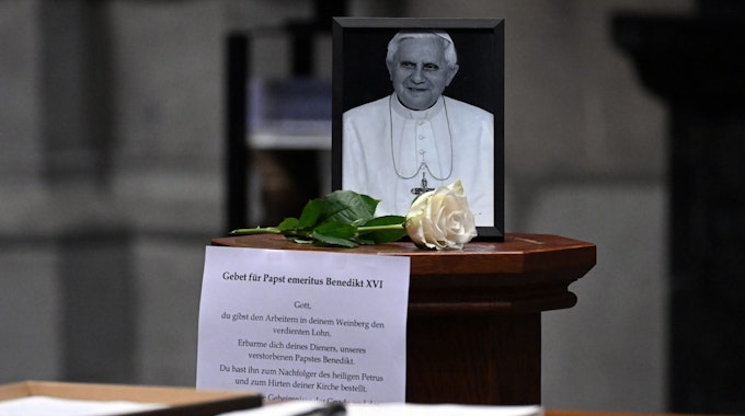 Ein Foto des emeritierten Papstes Benedikt XVI. steht im Kölner Dom.