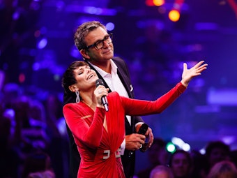 Die Moderatoren Francine Jordi (vorne) und Hans Sigl (hinten) stehen auf der Bühne. Die von F. Jordi H. Sigl moderierte Show wird am 31. Dezember 2022 ab 20.15 Uhr im Ersten (ARD), auf SRF 1 und ORF 2 ausgestrahlt.