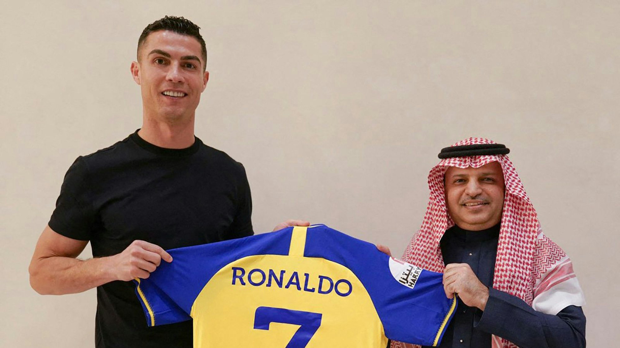 A handout picture released by Saudi Arabia's Al Nassr football club on their Twitter account shows Portugal's forward Cristiano Ronaldo being presented with the club's number seven jersey by club president Musalli Al-Muammar in Madrid on December 30, 2022 upon signing for the Saudi Arabian club. - Ronaldo signed for Al Nassr of Saudi Arabia, the club announced, in a deal believed to be worth more than 200 million euros. The 37-year-old penned a contract which will take him to June 2025. (Photo by Al Nassr Football Club / AFP) / == RESTRICTED TO EDITORIAL USE - MANDATORY CREDIT "AFP PHOTO / HO /AL NASSR FOOTBALL CLUB" - NO MARKETING NO ADVERTISING CAMPAIGNS - DISTRIBUTED AS A SERVICE TO CLIENTS ==