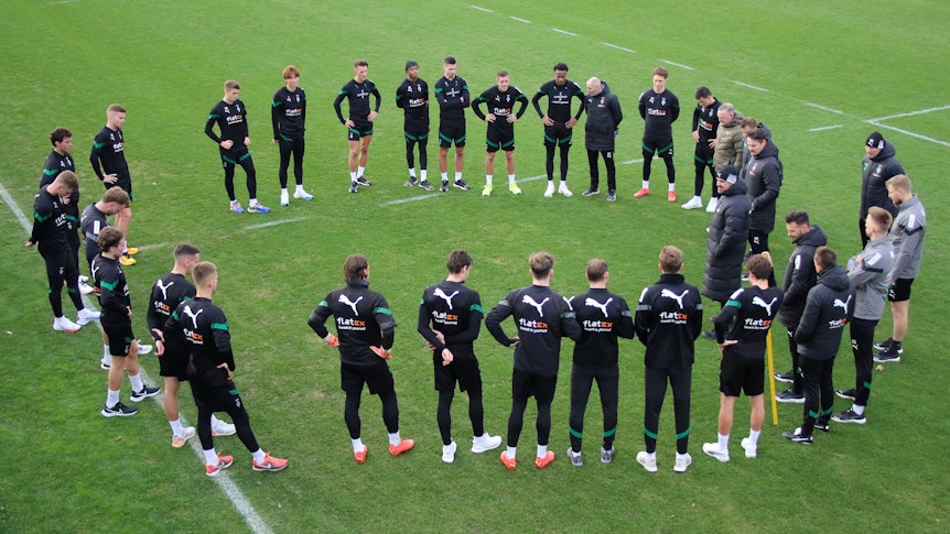 Die Mannschaft von Borussia Mönchengladbach im Kreis beim Training am 31. Dezember 2022 im Borussia-Park. Trainer Daniel Farke steht in der Mitte und spricht zu seinen Spielern.