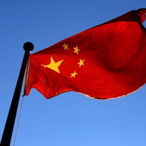 Die Fahne Chinas weht vor einem strahlend blauen Himmel.