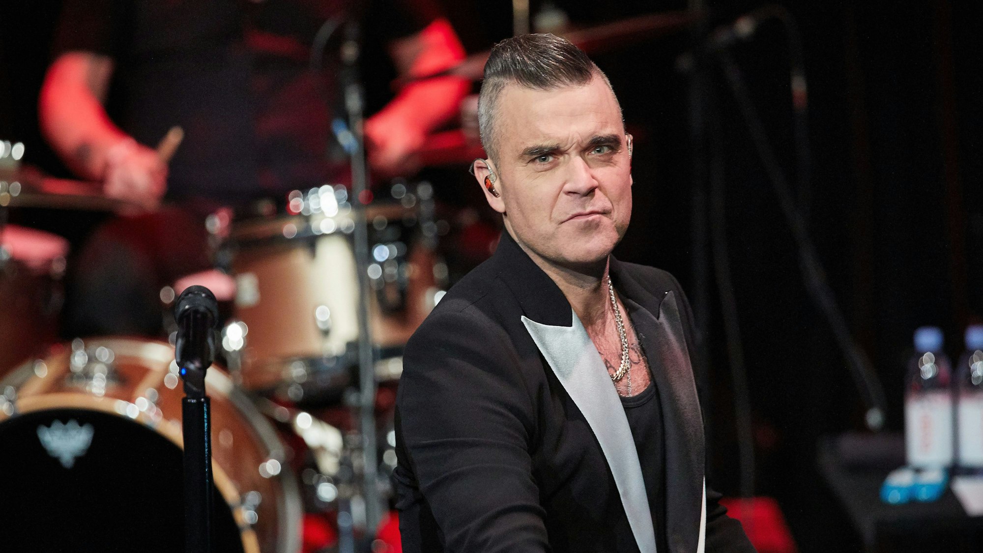 ARCHIV - 05.12.2019, Hamburg: Der Sänger Robbie Williams steht auf der Bühne