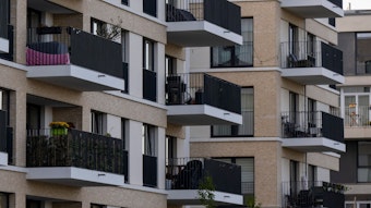 Zu sehen sind mehrere neu gebaute Wohnhäuser, deren Balkone dicht aneinander liegen.