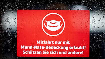 Ein Schild mit der Aufschrift „Mitfahrt nur mit Mund-Nase-Bedeckung erlaubt! Schützen Sie sich und andere!“ klebt an der Zugtür eines ICE der Deutschen Bahn