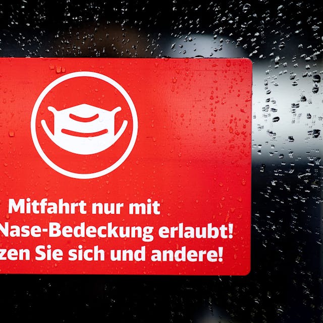 Ein Schild mit der Aufschrift „Mitfahrt nur mit Mund-Nase-Bedeckung erlaubt! Schützen Sie sich und andere!“ klebt an der Zugtür eines ICE der Deutschen Bahn