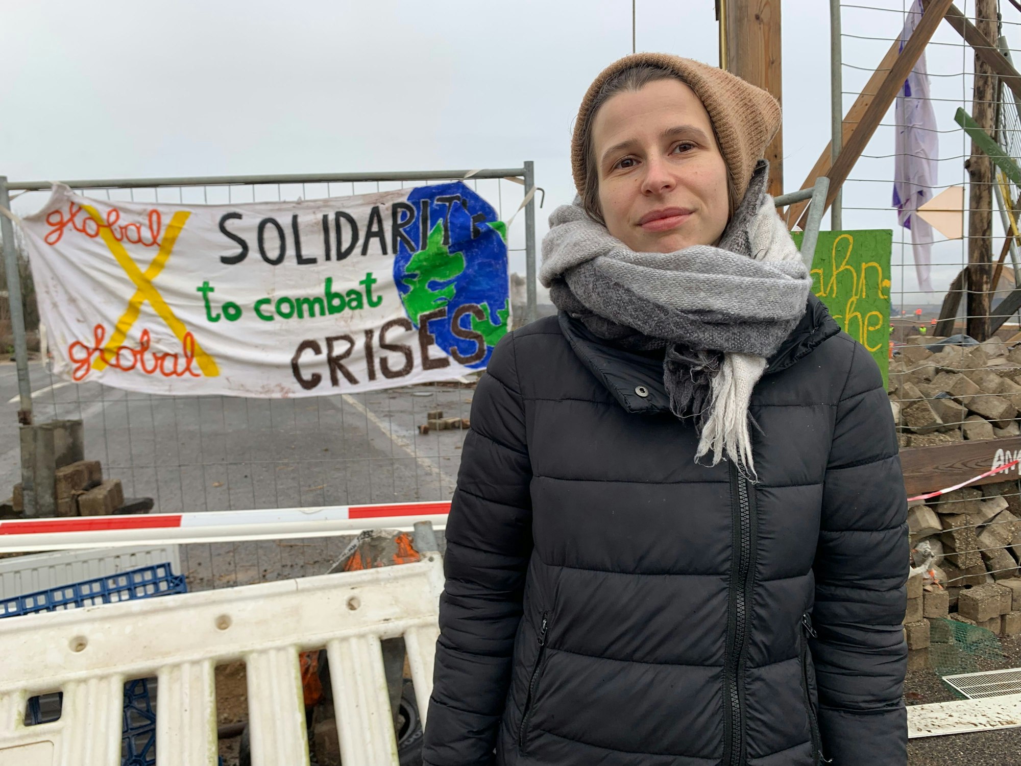 Julia Riedel von der Initiative "Lützerath lebt" steht am Montag vor einer Barrikade auf der Zufahrt zu dem Braunkohledorf Lützerath, das ab Mitte Januar geräumt werden soll.