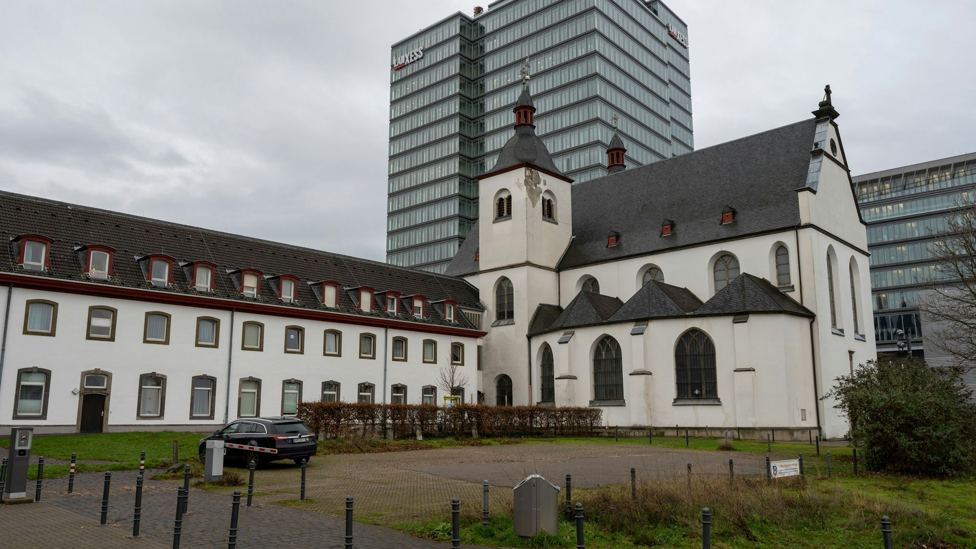 Der Parkplatz neben dem ehemaligen Kloster St. Heribert in Deutz, dahinter das Lanxess-Hochhaus