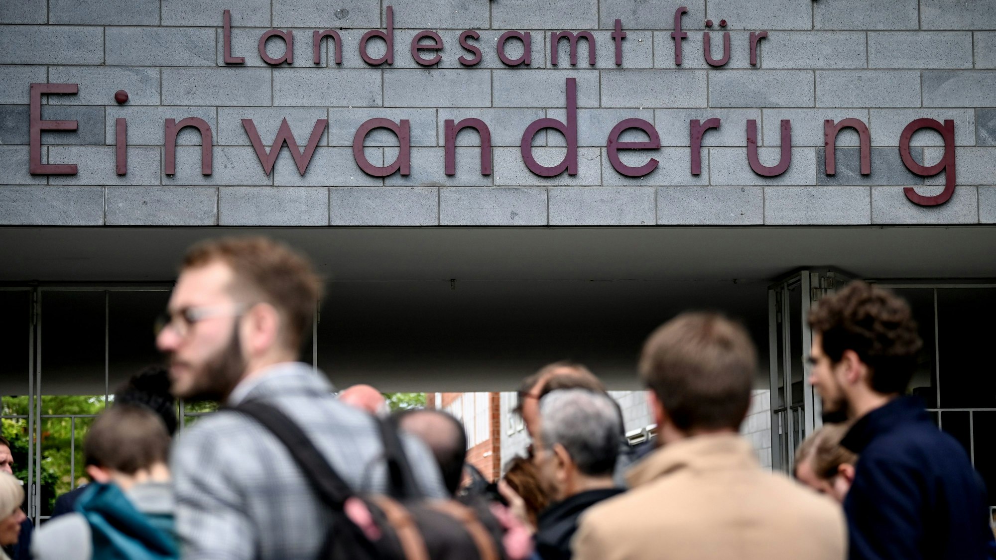 Menschen stehen vor dem Berliner Landesamt für Einwanderung in Berlin