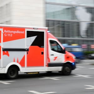 Ein Rettungswagen fährt über eine Straße in Köln.