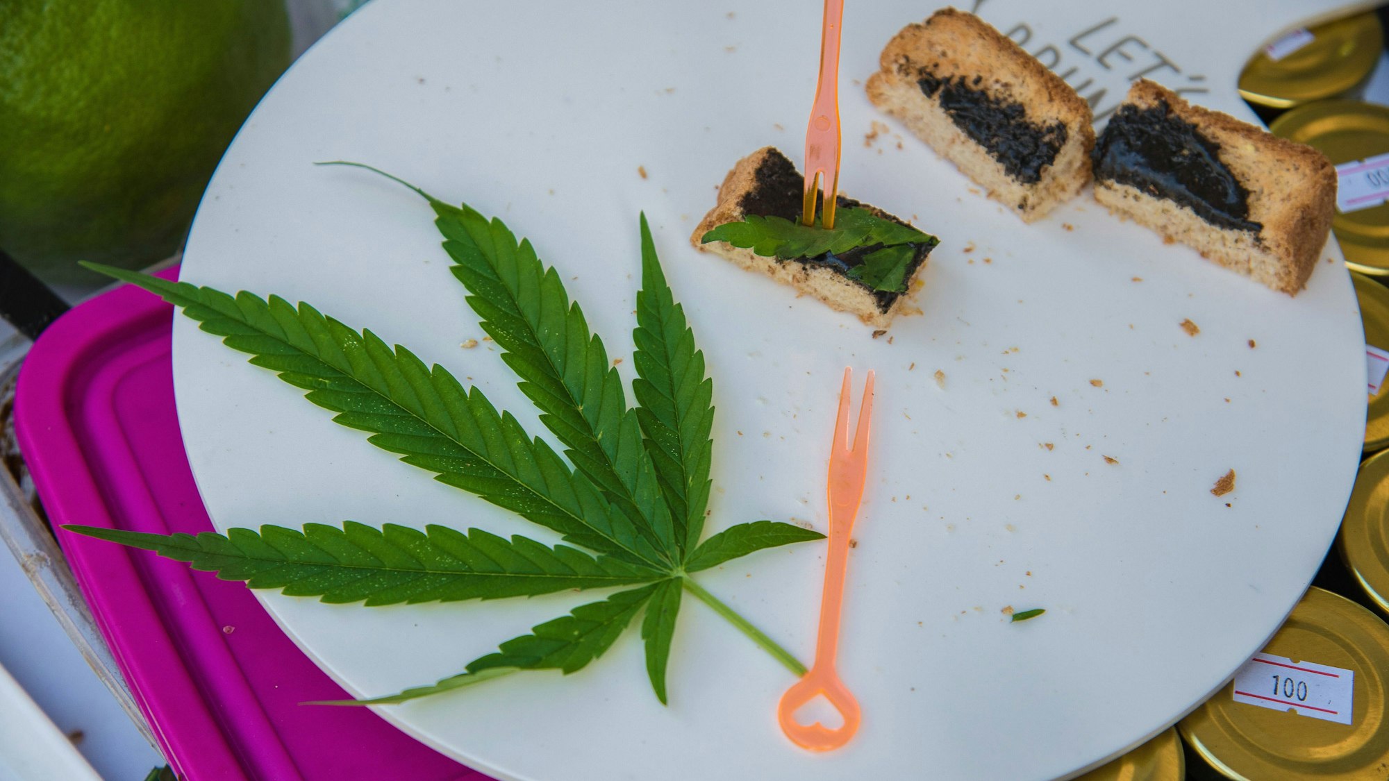 Auf einem Teller liegt Kuchen und ein Cannabis-Blatt.