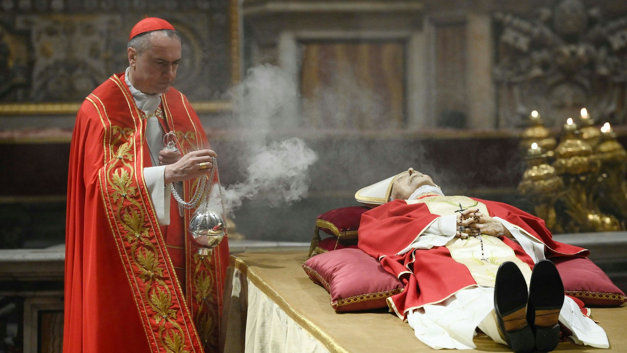 Kardinal Mauro Gambetti, Generalvikar des Papstes für die Vatikanstadt und Erzpriester des Petersdoms, schwenkt ein Weihrauchfass neben dem aufgebahrten Leichnam des emeritierten Papstes Benedikt XVI. im Petersdom.