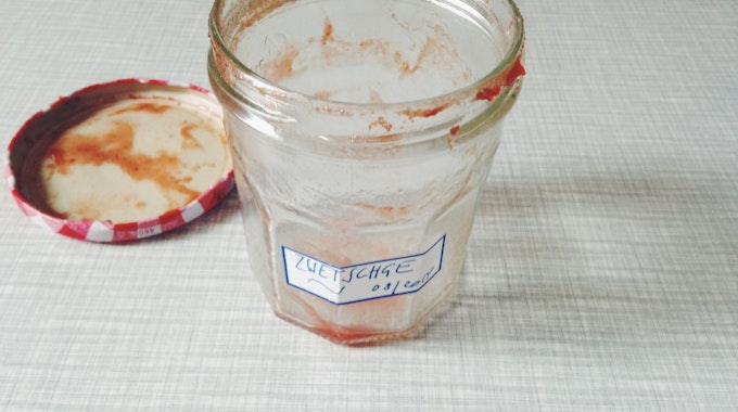 Ein leer gelöffeltes Marmeladenglas mit einem selbstgeschriebenen Etikett.