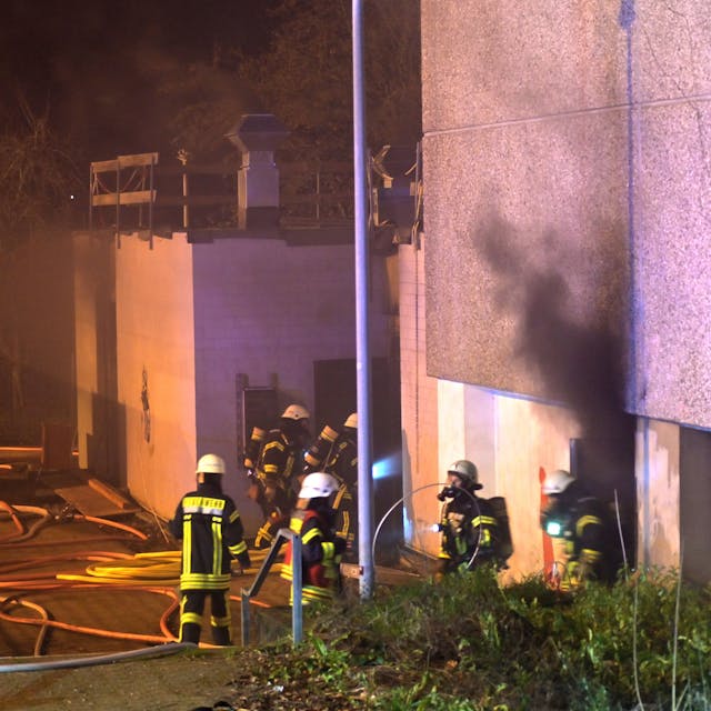 Die Sporthalle der Gesamtschule in Schlebusch brennt in der Nacht, Feuerlehrkräfte bekämpfen das Feuer.