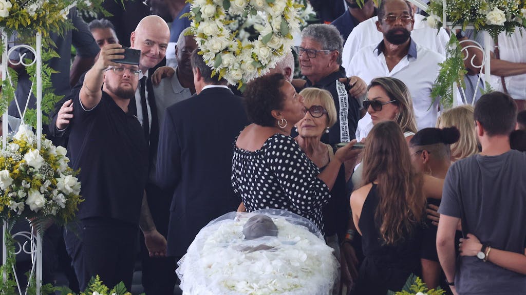 Makabere Szene bei der Totenwache für Pelé: Links posiert Fifa-Präsident Gianni Infantino für ein Selfie, keinen Meter entfernt liegt der Leichnam der Fußball-Legende.