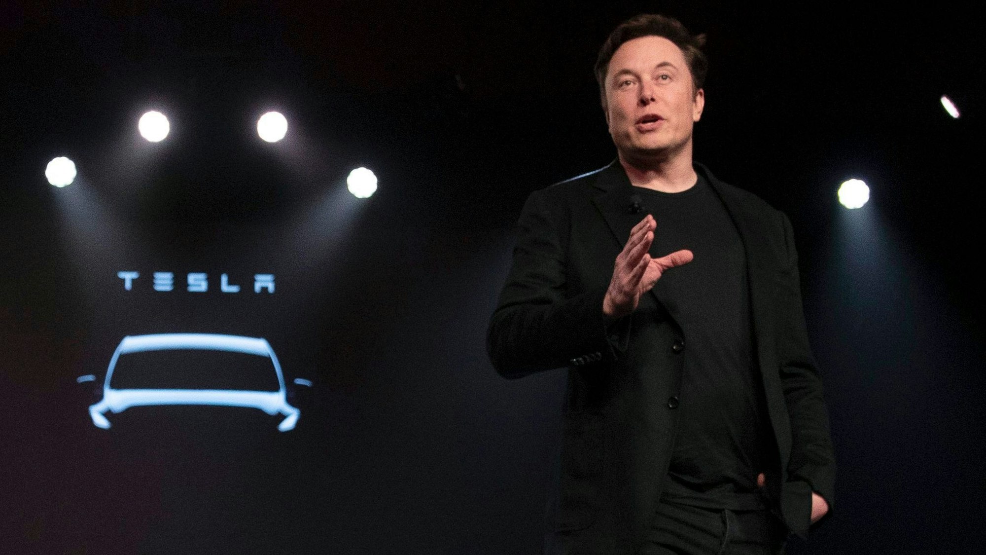 FILE - Tesla CEO Elon Musk 2019 bei der Präsentation eines neues Tesla-Modells auf der Bühne. Das Tesla-Logo ist im Hintergrund zu sehen.