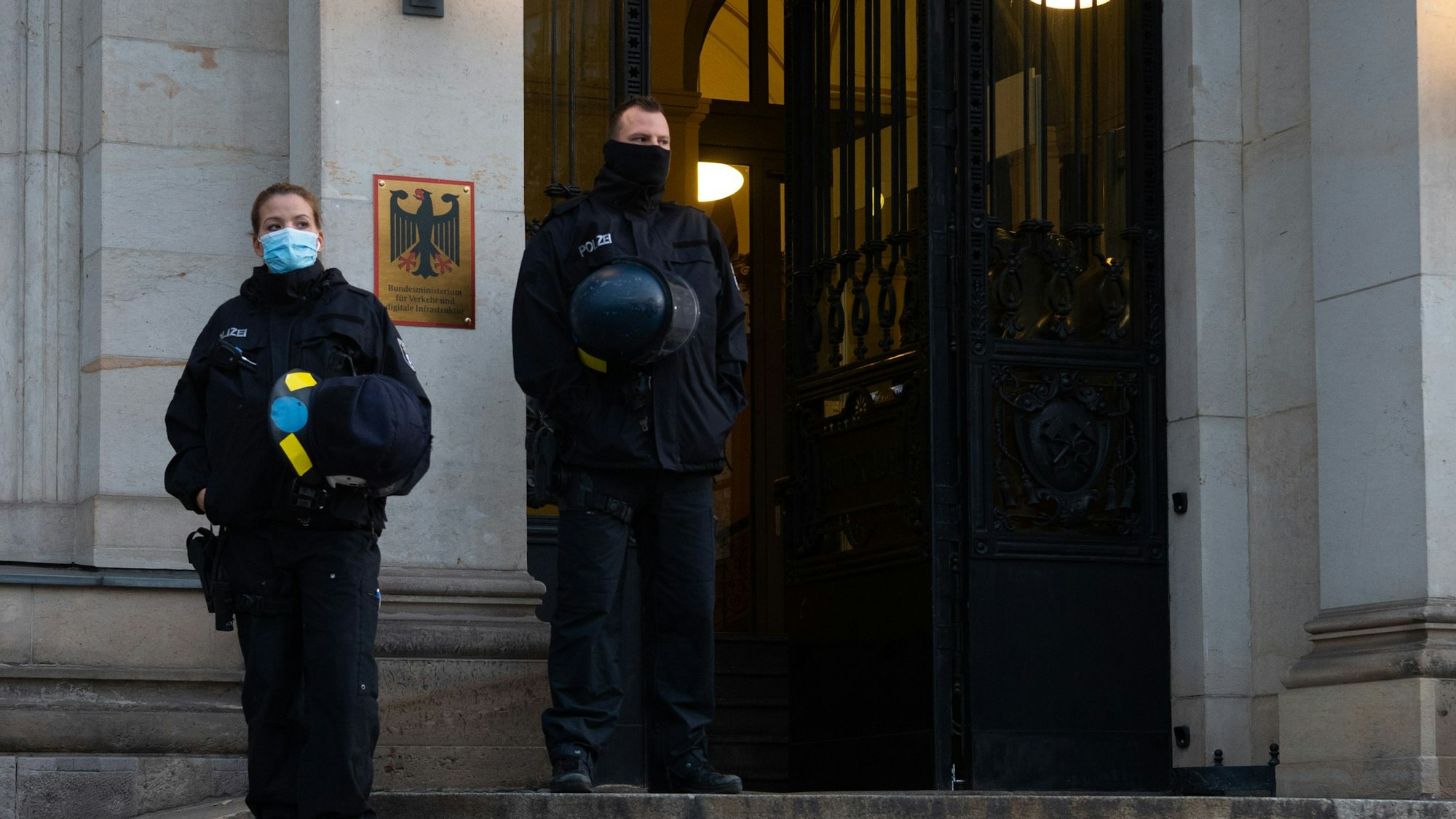 Polizisten sichern den Haupteingang zum Bundesverkehrsministerium. Sie stehen auf der Treppe vor dem Gebäude, dessen Tür geöffnet ist. (Archivbild)