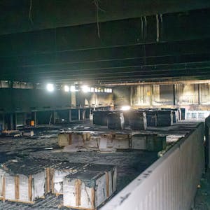 Die ausgebrannte Sporthalle der Gesamtschule Schlebusch ist jetzt Rußschwarz: Dämmmaterial liegt in der Halle. Foto: Ralf Krieger