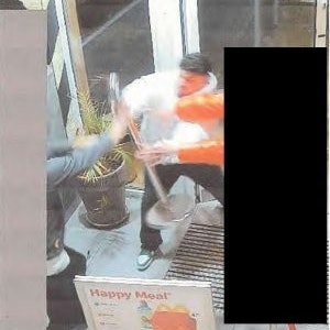 Ein Mann greift nach einer Absperrstange aus Metall. Das Foto stammt aus einer Überwachungskamera.