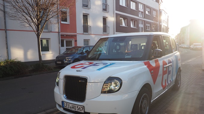 Ein weißes Auto in Form der Londoner Taxen mit der Aufschrift „Efi“ in der Birkenbergstraße.