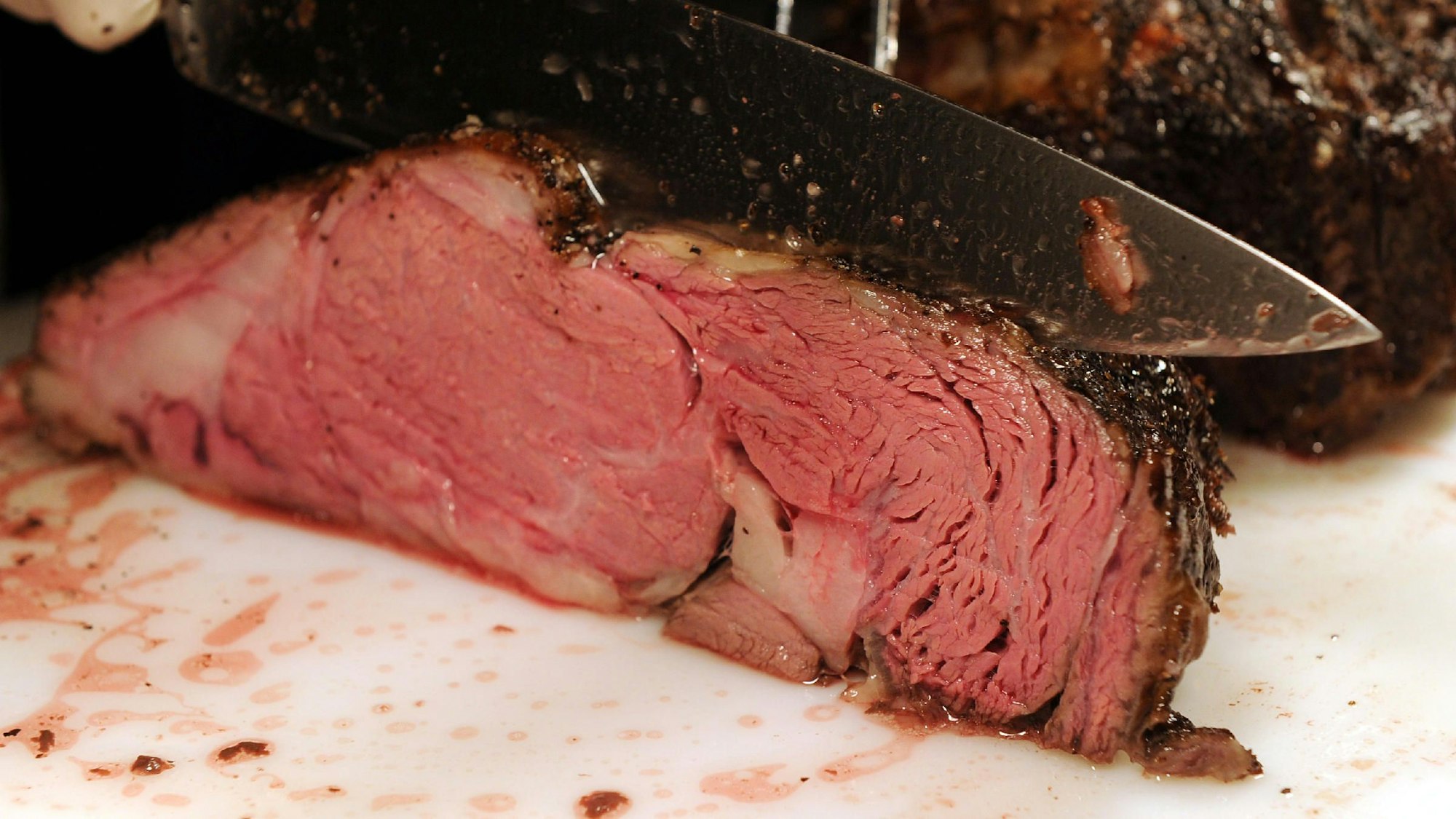 Das Foto zeigt ein Stück Rindfleisch, das aufgeschnitten wird.