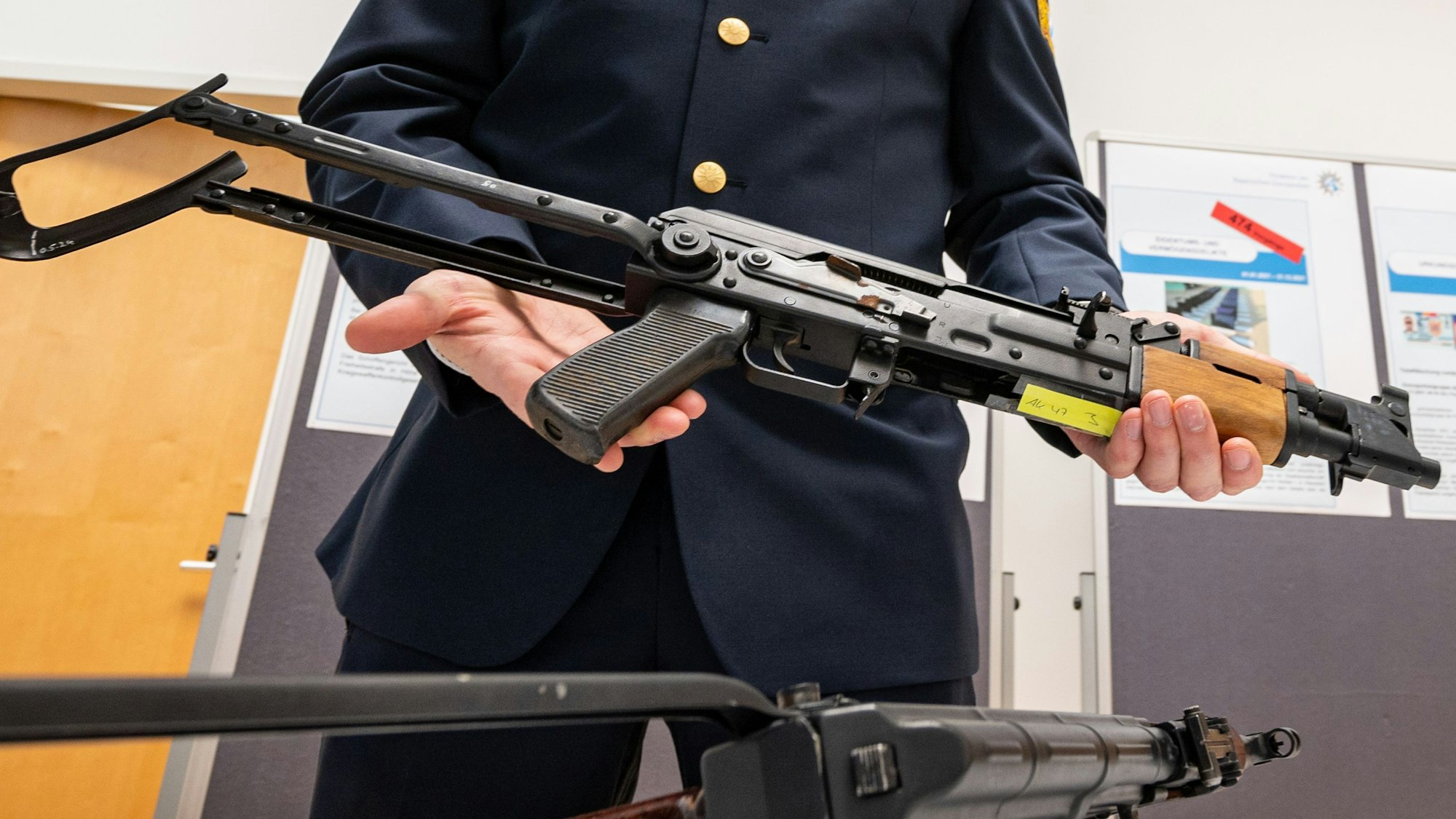 Ein Polizist zeigt eine sichergestellte umgebaute AK-47 Kalaschnikow.